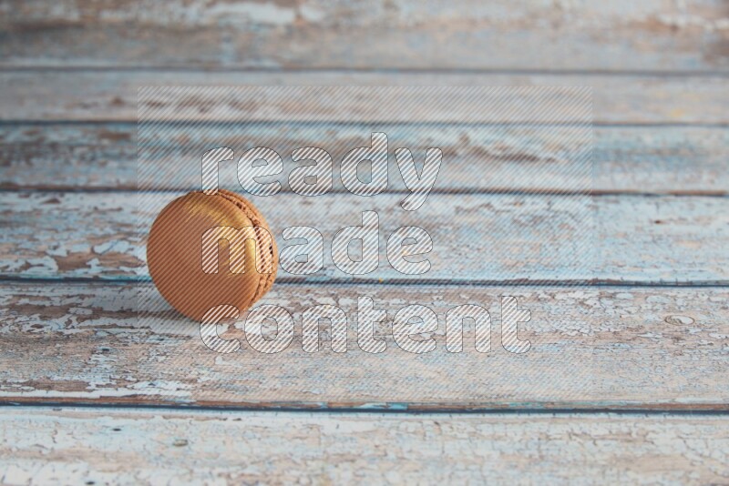 45º Shot of Brown Coffee macaron on light blue wooden background