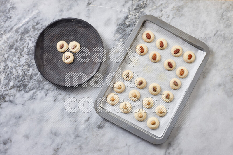 Ghoriba step by step with its ingredient, flour, powdered sugar, ghee and nuts on grey marble background