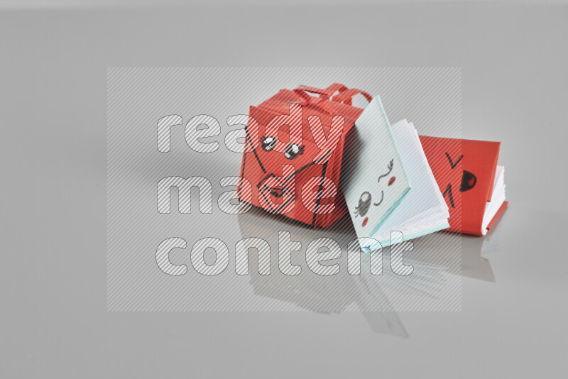 Origami school supplies such as back bag, books and ruler on grey background