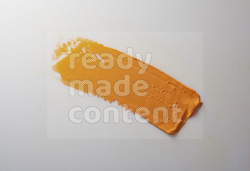 An orange straight painting knife stroke on white background
