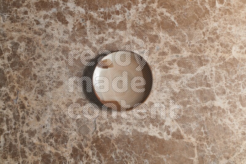 A decorative pottery plate on beige marble background