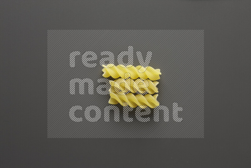 Fusilli pasta on grey background