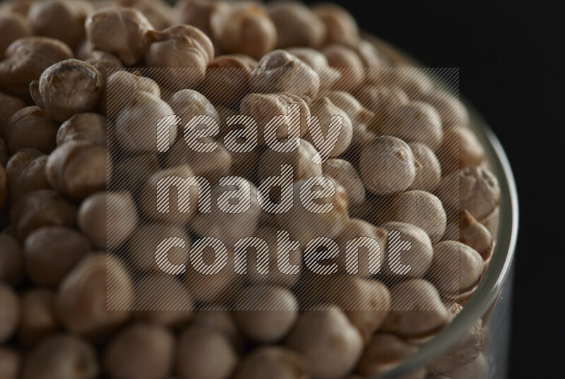 Chickpeas in a glass jar on black background