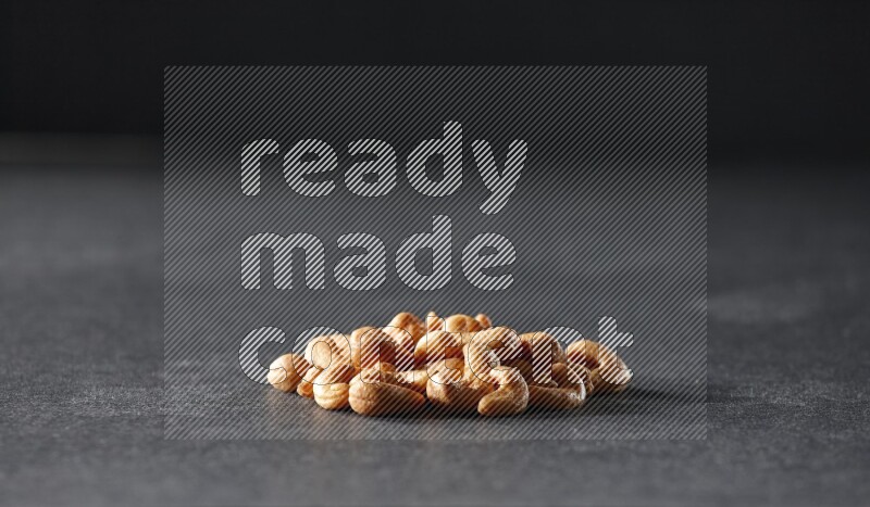 A bunch of cashews on a black background in different angles