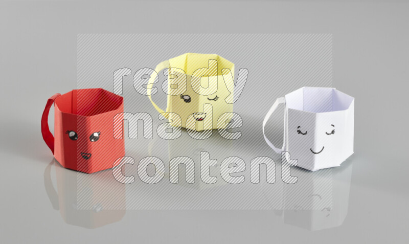 Origami cup on grey background