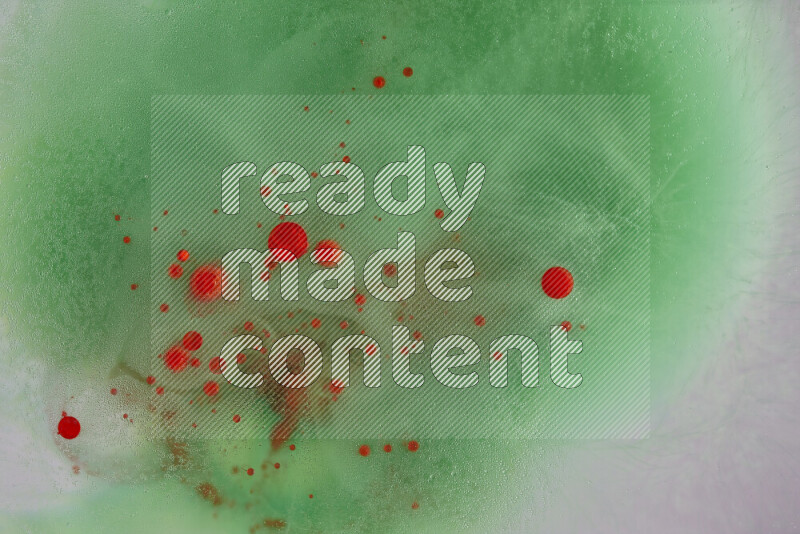 The image captures a dramatic splatter of red paint over a green backdrop