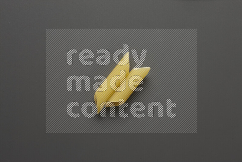 Penne pasta on grey background
