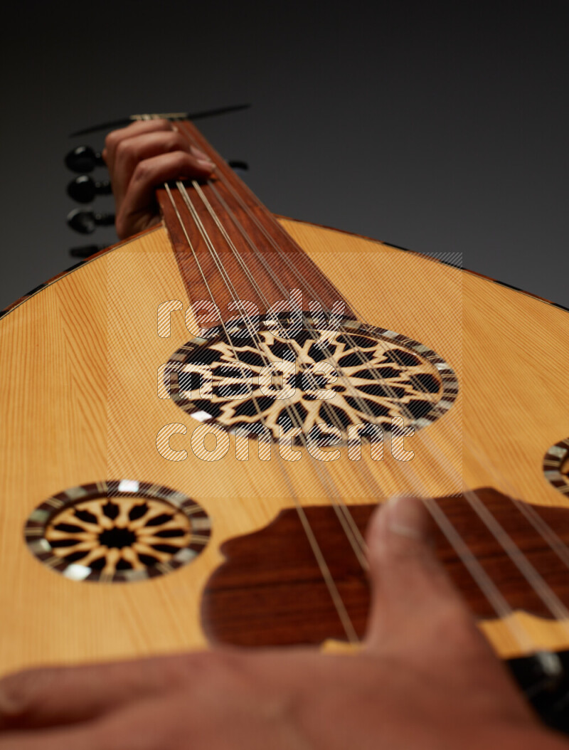 يد رجل تعزف على عود خشبي بني