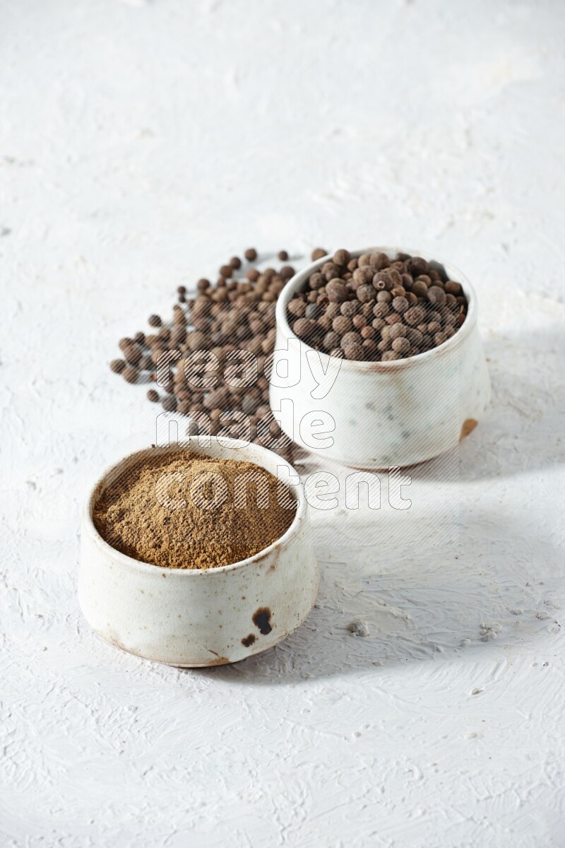 2 beige bowls, one full of powder and the other full of whole balls with balls and powder spreaded on a textured white flooring
