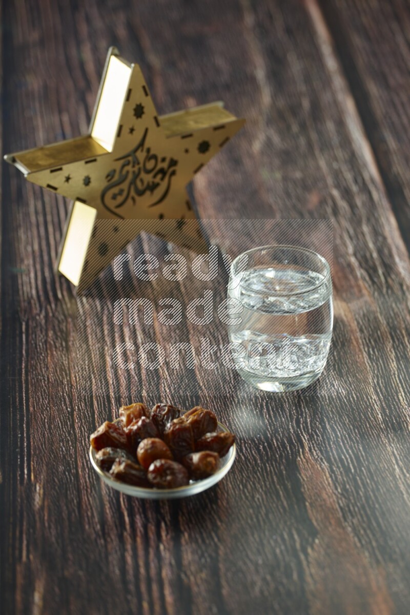 A wooden golden star lantern with different drinks, dates, nuts, prayer beads and quran on brown wooden background