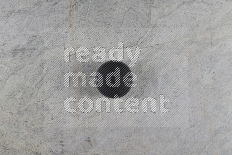 A black pottery bowl on grey marble background