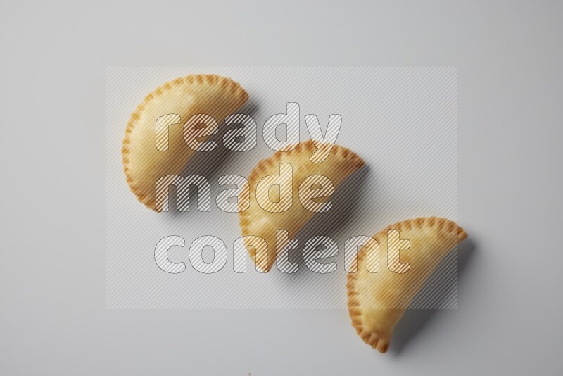 Three fried sambosa from a top angle on a white background