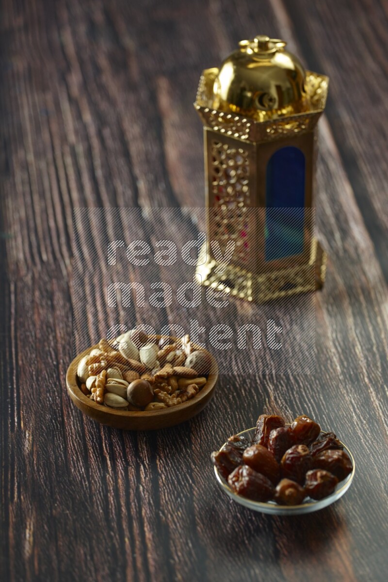 A golden lantern with different drinks, dates, nuts, prayer beads and quran on brown wooden background