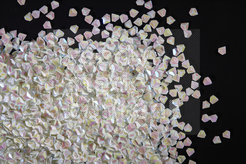 Colorful plastic shards for decoration scattered on a black background