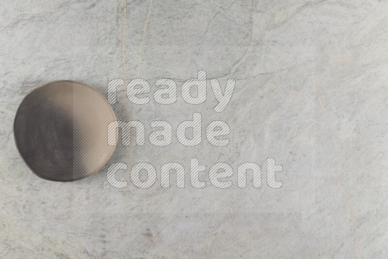 A multicolored pottery plate on grey marble background