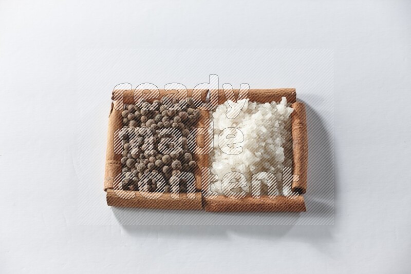 2 squares of cinnamon sticks full of white salt and allspice on white flooring