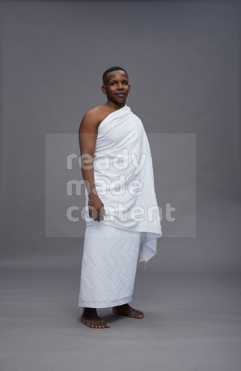 A man wearing Ehram Standing Interacting with the camera on gray background