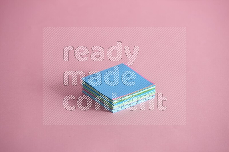Stacked multicolored sticky notes on rose background