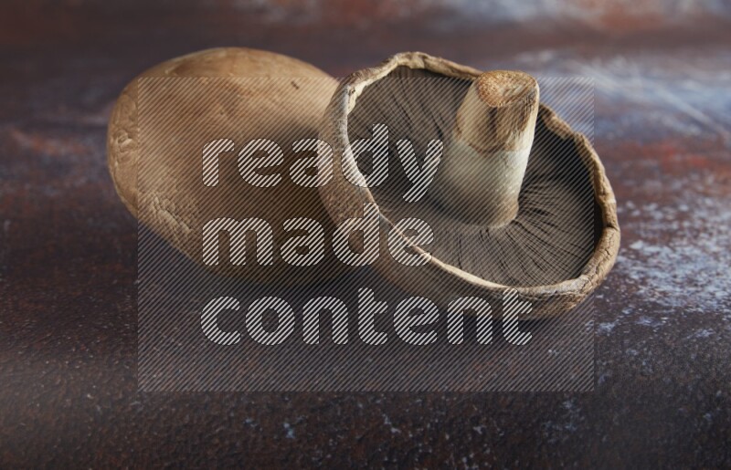 45 degre portobello mushrooms on a textured reddish rustic metal background