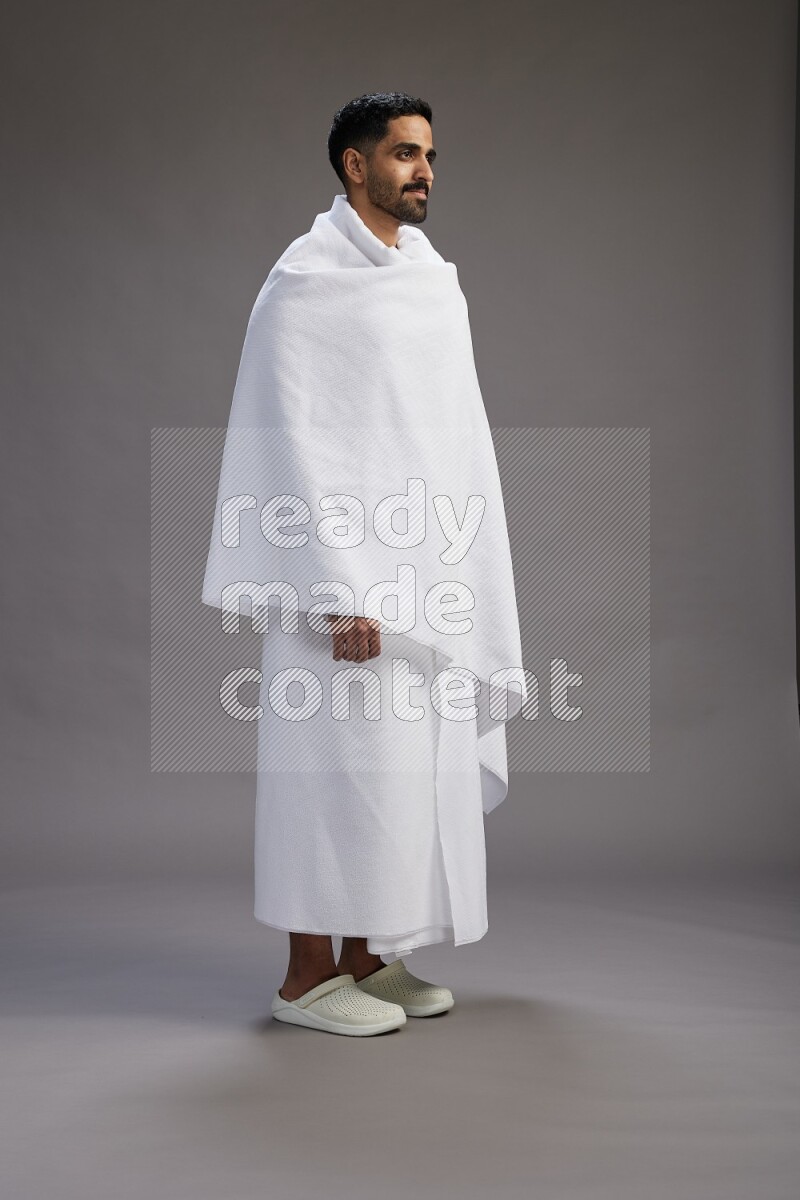 A man wearing Ehram Standing Interacting with the camera on gray background