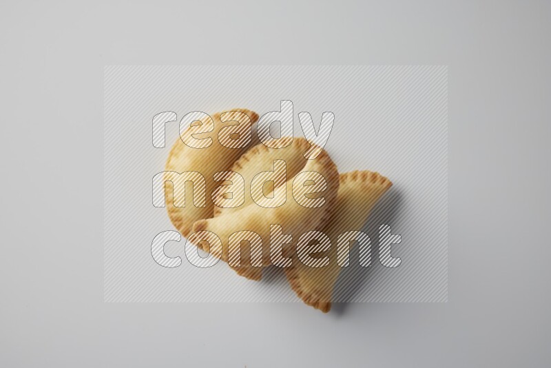 Four fried sambosa from a top angle on a white background