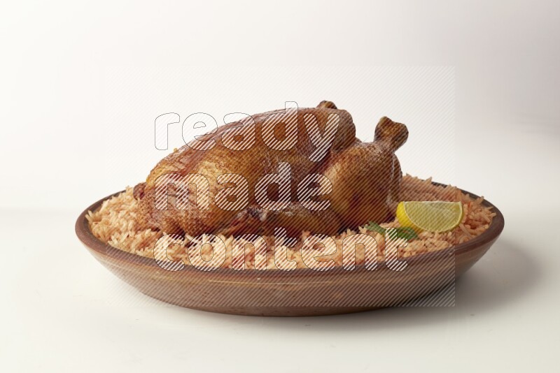 red basmati Rice with whole roasted chicken on a pottery plate direct on white background