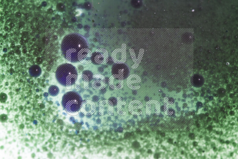 Close-ups of abstract green and blue watercolor drops on oil Surface on white background