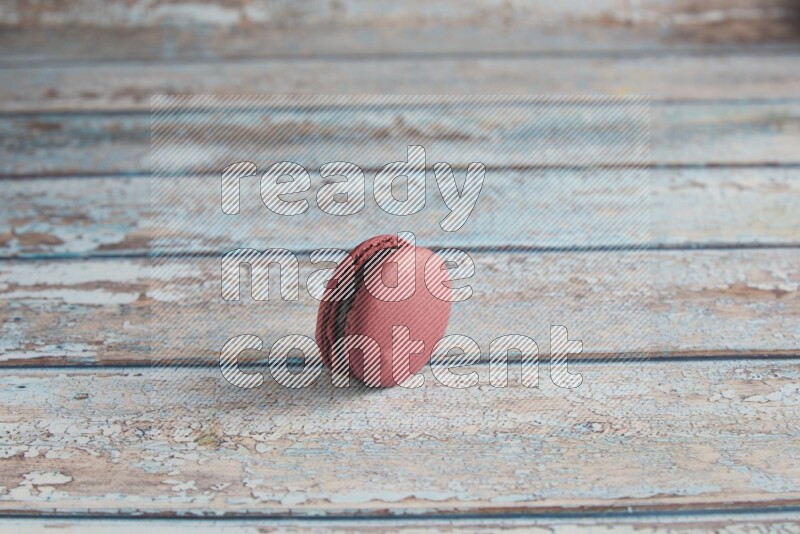 45º Shot of Red Cherry macaron on light blue wooden background