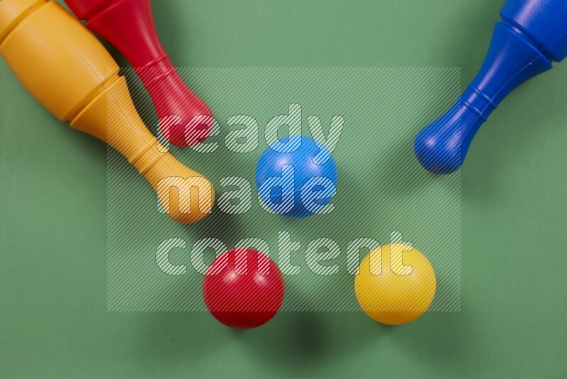 Plastic bowling pins with balls on different colored backgrounds (kids toys)