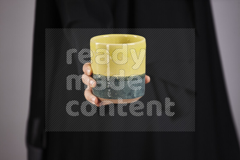 امرأة ترتدي عباءة سوداء تحمل أدوات فخارية مختلفة في أوضاع متعددة