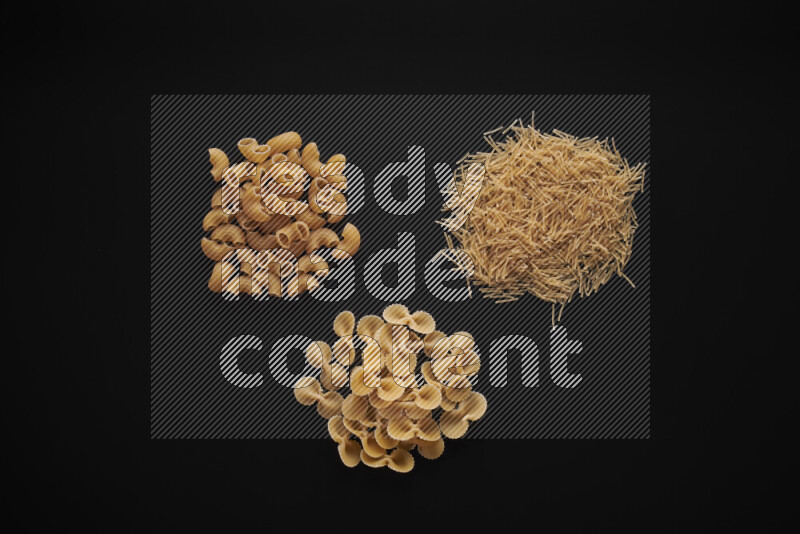 Different pasta types in bunches on black background
