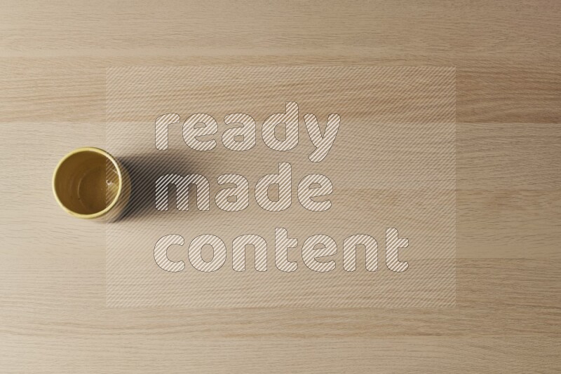 كأس فخاري متعدد الألوان على خلفية خشبية فاتحة