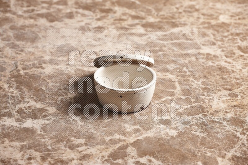 A white pottery bowl on beige marble background