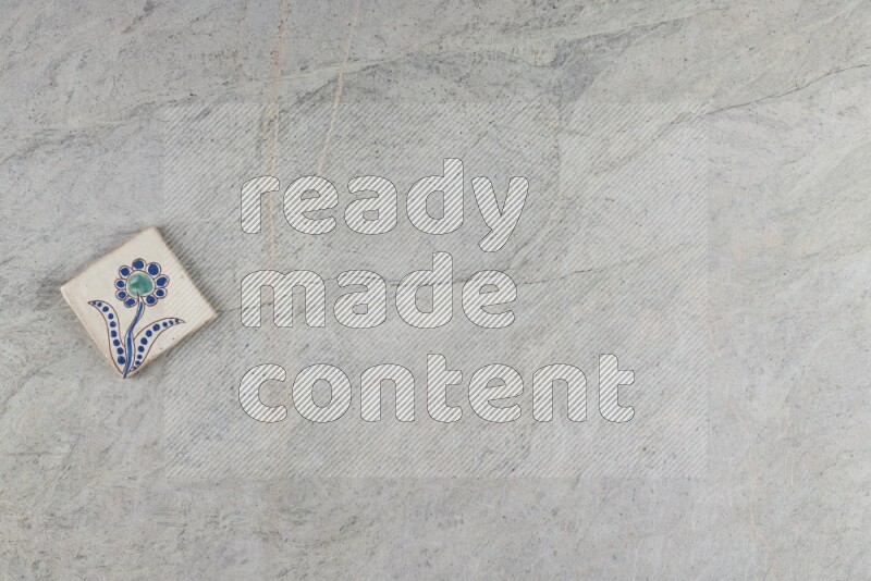 A decorative pottery coaster on grey marble background