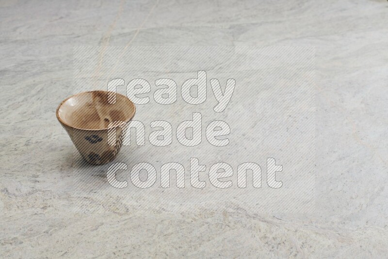 A multicolored pottery Cup on grey marble background