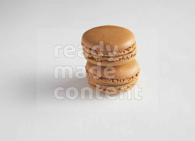 45º Shot of two Brown Maple Taffy macarons on white background