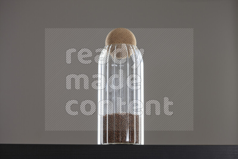 Brown lentils in a glass jar on black background