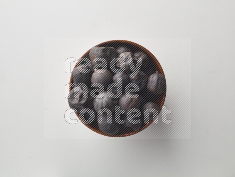 Top-view shot of dried lime (loomi) in a container on white background