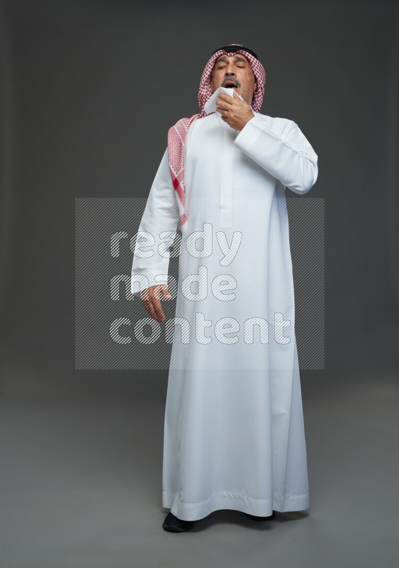 Saudi man with shomag Standing feeling sick on gray background