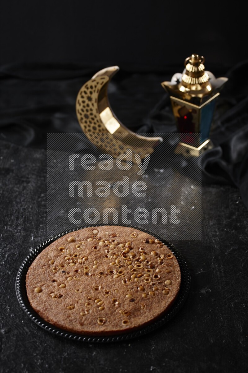 بسبوسة مع فوانيس علي خلفية سوداء خشبية