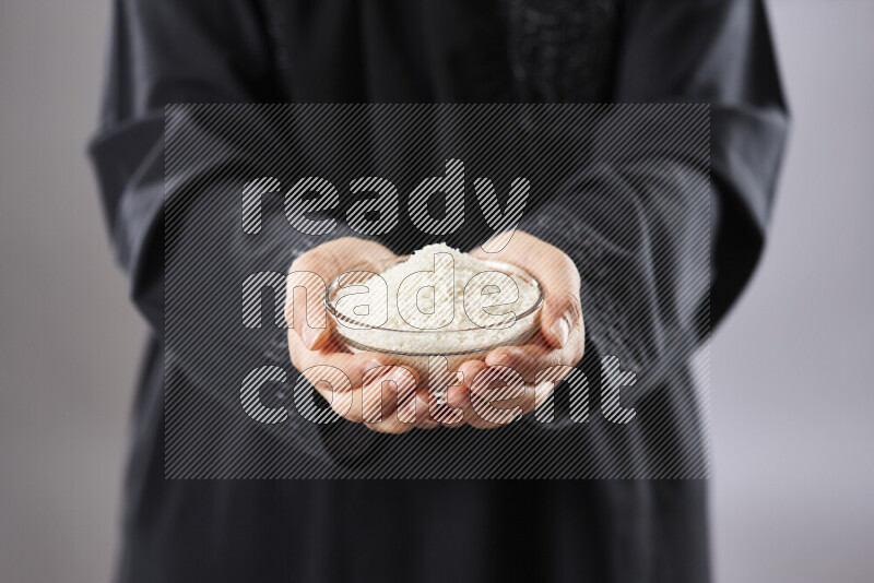 Woman in abaya holding different kinds of nuts in different positions