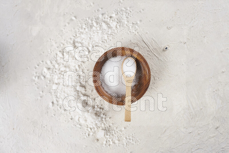 A pottery plate full of fine salt with bunch of coarse salt beside it on white background