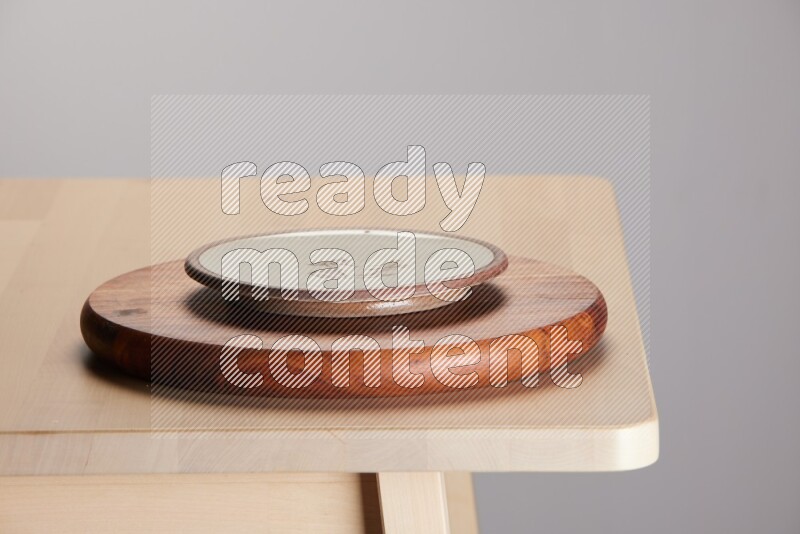 multi-colored pottery Plate placed on a dark colored wooden tray on the edge of wooden table