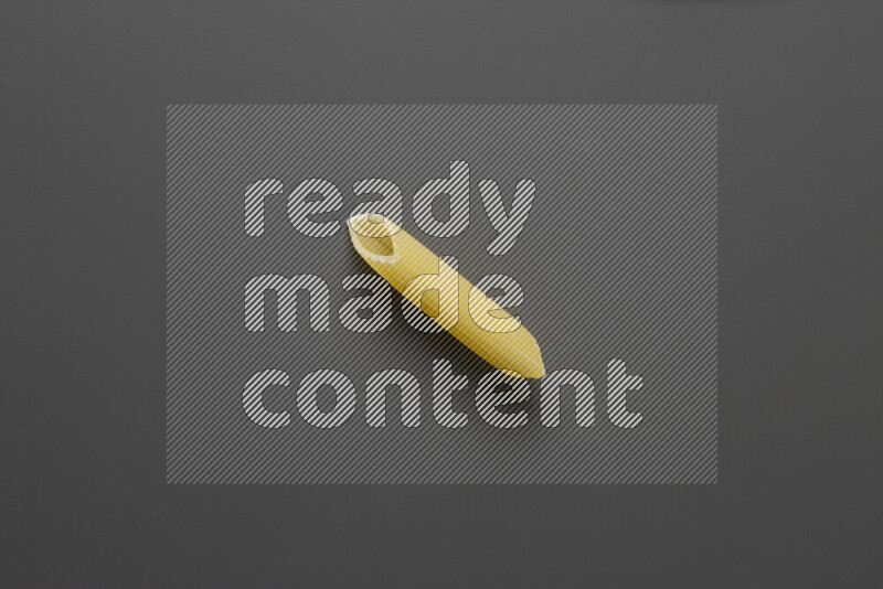 Penne pasta on grey background