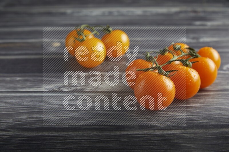 Mixed cherry tomato veins on a textured grey wooden background 45 degree