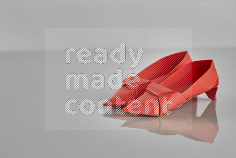 Origami shoes on grey background
