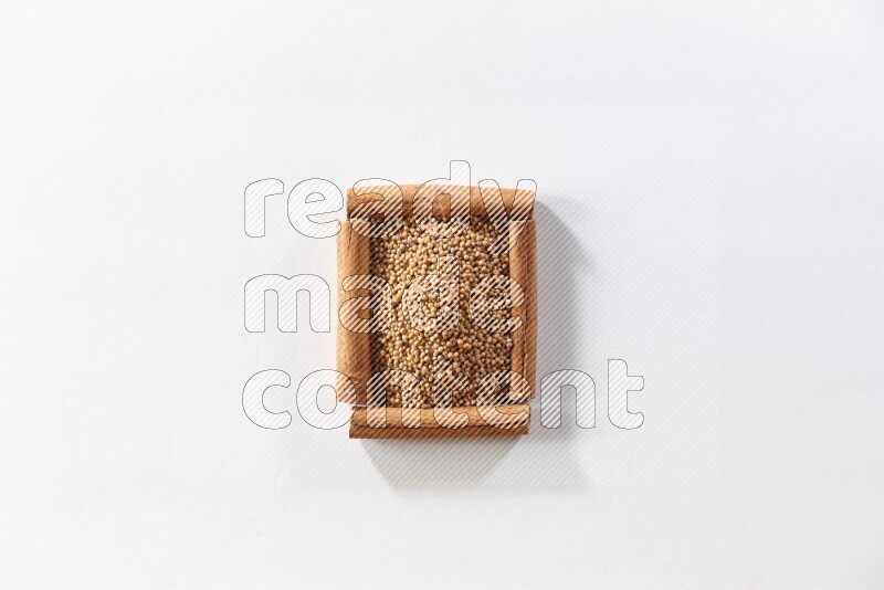 A single square of cinnamon sticks full of mustard seeds on white flooring