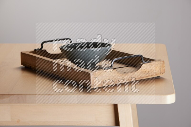 grey bowl on a light colored rectangular wooden tray with handles