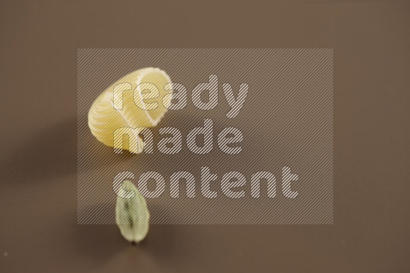 معكرونة مع مكونات متنوعة من الطماطم والثوم والبصل والفلفل الأحمر والفلفل الأسود والفلفل الأبيض وأوراق الغار وإكليل الجبل والهيل على خلفية بيج