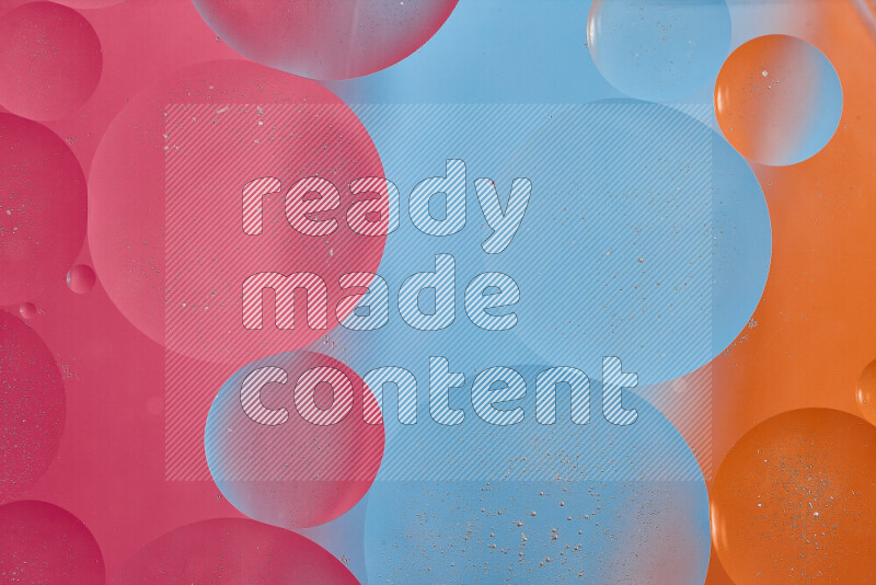 Close-ups of abstract oil bubbles on water surface in shades of blue, orange and pink